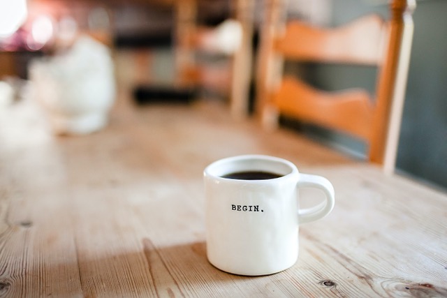 White coffee mug on table with the word begin