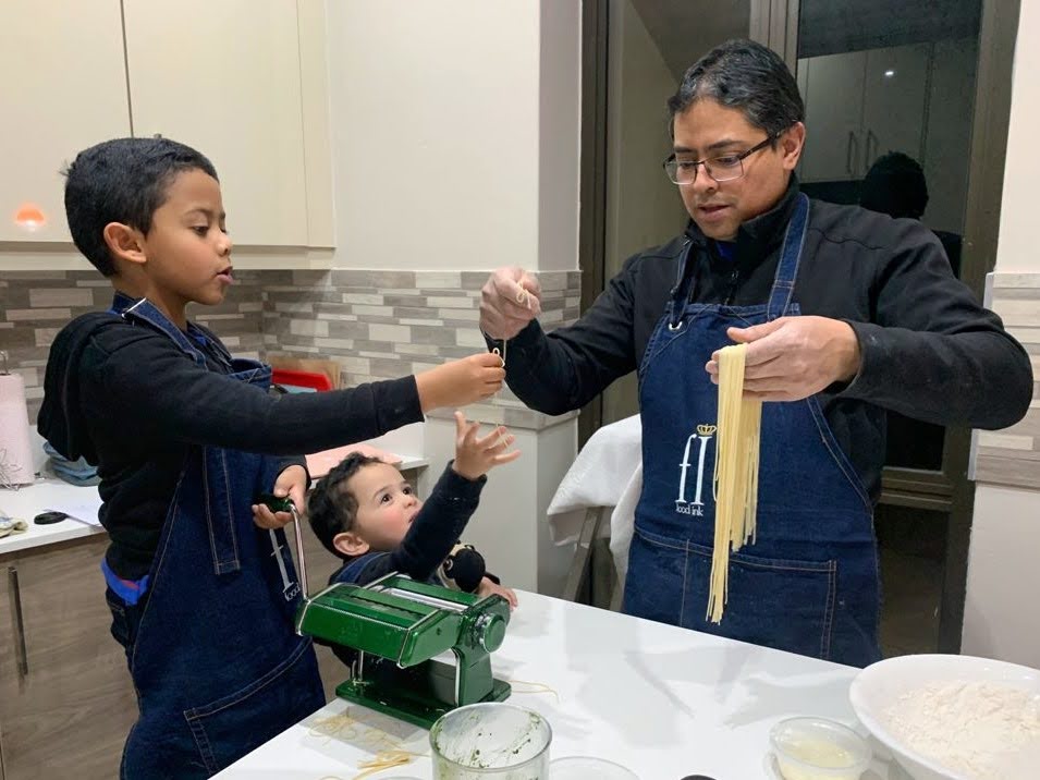 dad and kids making pasta