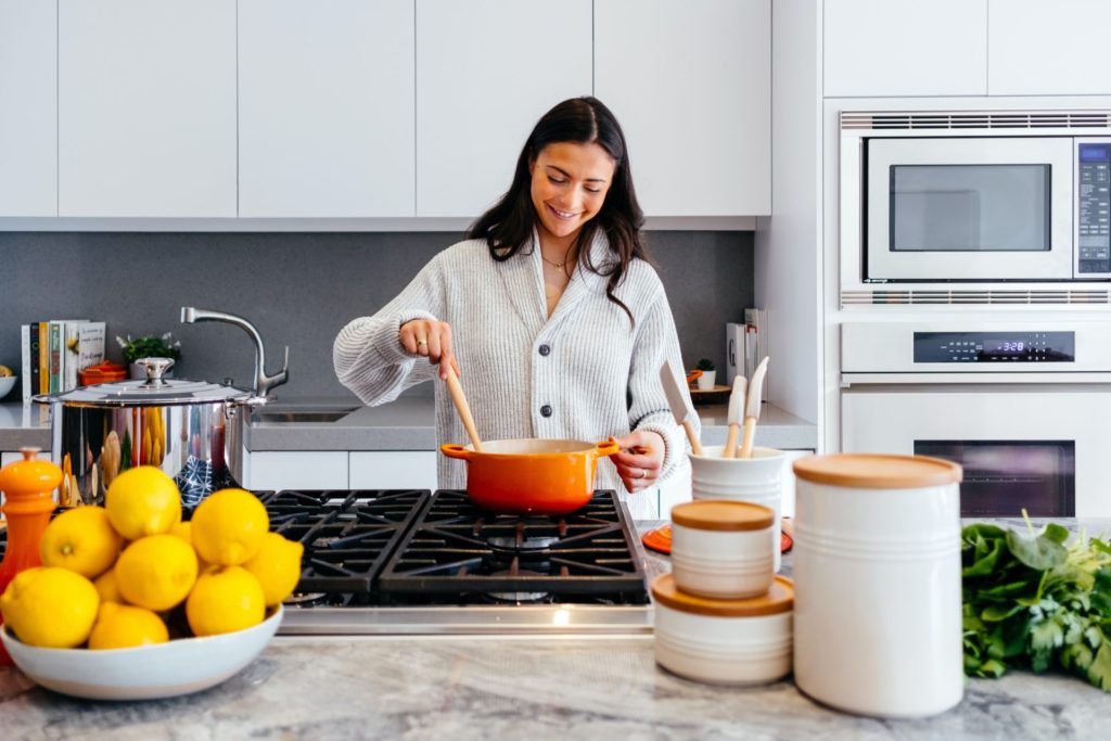 Woman stirring pot in kitchen