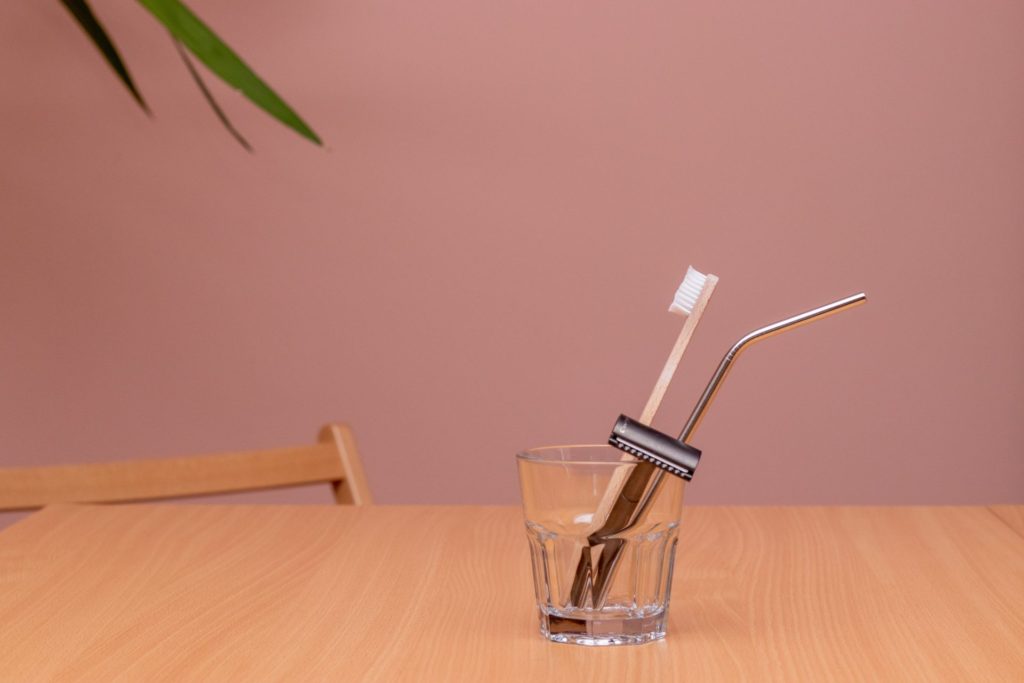 Glass with toothbrush, razor and straw