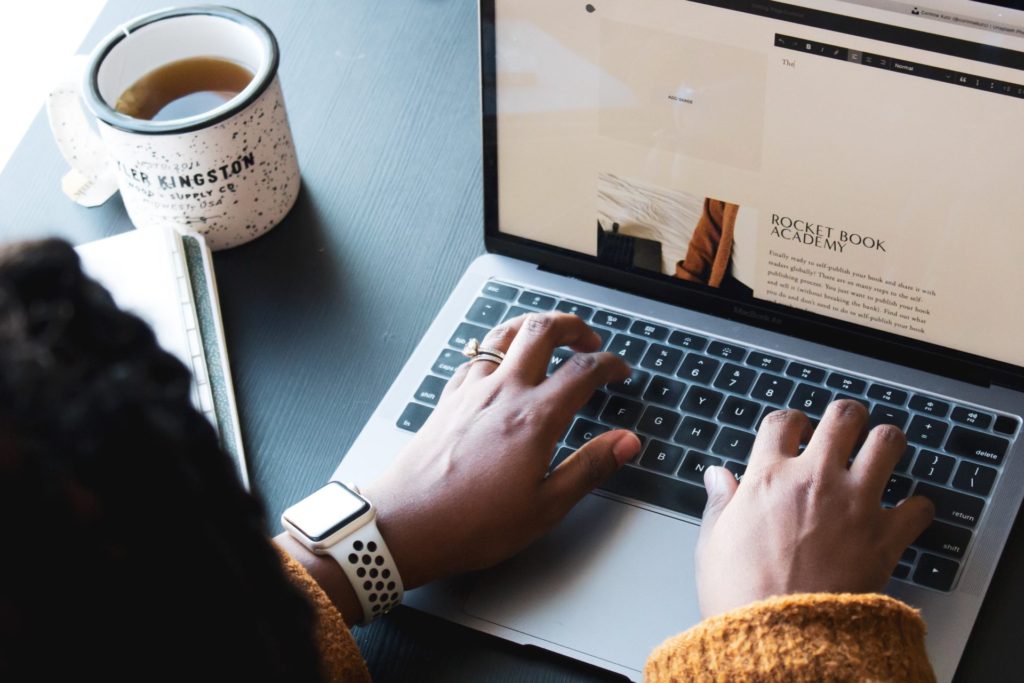 Woman sitting at desk, typing on laptop