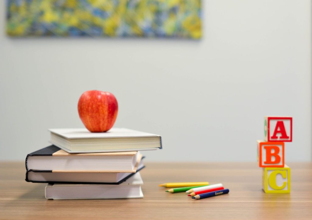 School desk with an apple on top of books