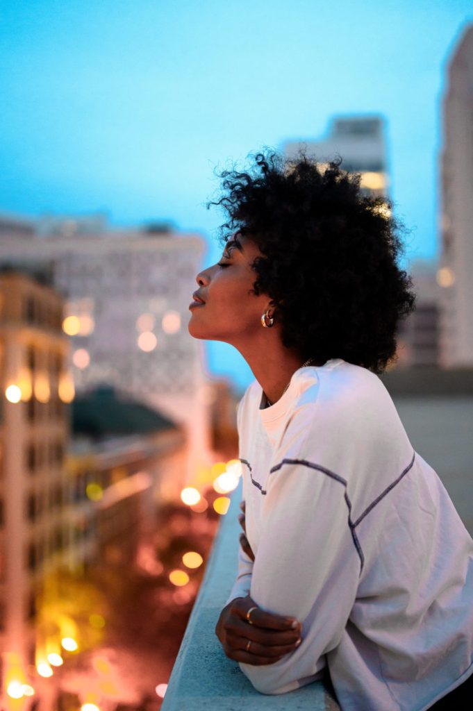 Woman on balcony, eyes closed