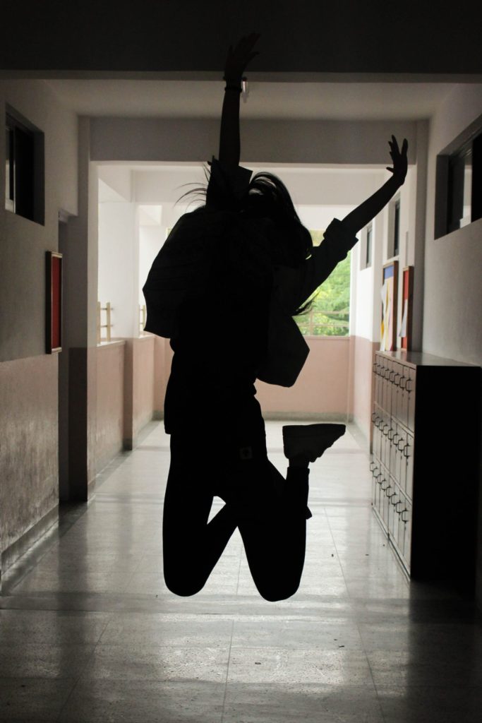 girl jumping with arms in air