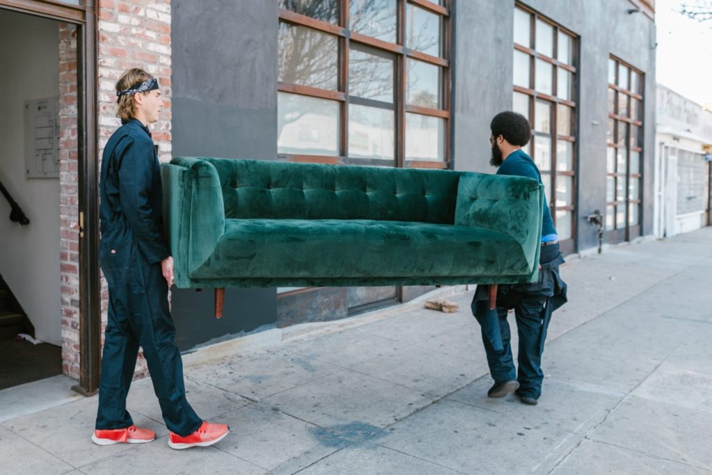 Two men carrying a couch