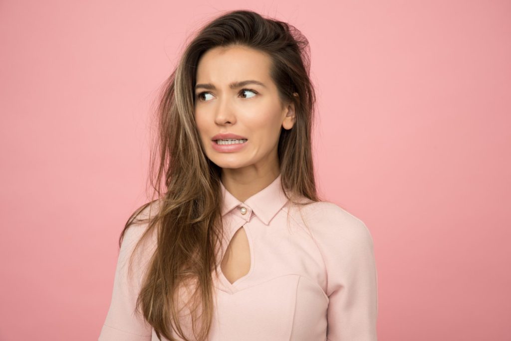 Lady with a grimace on pink background