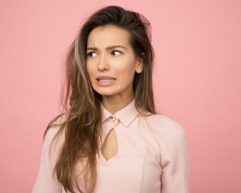 Lady with a grimace on pink background